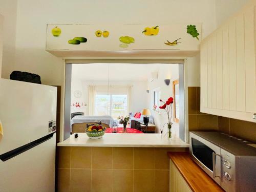 a kitchen with a white refrigerator and a kitchen with a room at Vila Vista Luz in Lagos