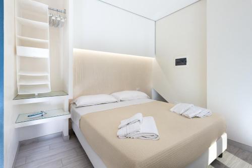una camera da letto con un letto e asciugamani bianchi di Rivazzurra Vivimare Apartment a San Vito lo Capo