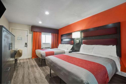 Bellville的住宿－Motel 6 Bellville, OH，酒店客房设有两张床和橙色的墙壁。