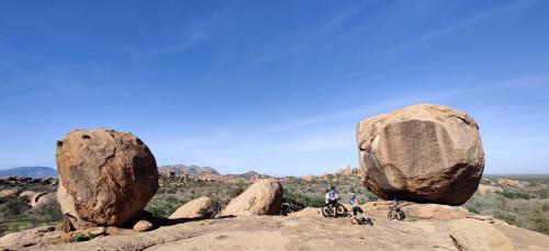 a group of people riding bikes on a rock formation at Ai Aiba - The Rock Painting Lodge in Omaruru