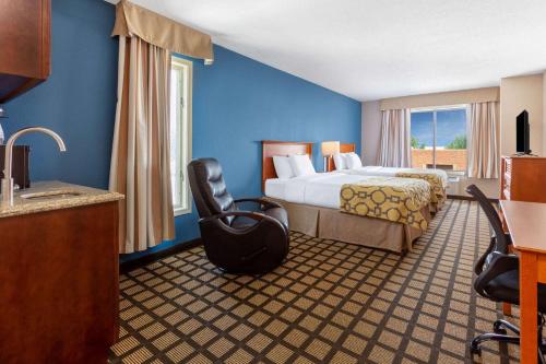 Pokój hotelowy z łóżkiem i krzesłem w obiekcie Baymont by Wyndham Rochester Mayo Clinic Area w mieście Rochester