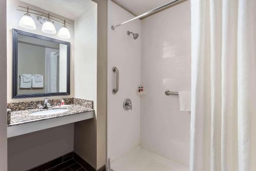 a bathroom with a shower and a sink and a mirror at Baymont by Wyndham Rochester Mayo Clinic Area in Rochester