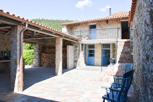 a patio with chairs in front of a building at Quinta da Borboleta in Vila Nova de Poiares