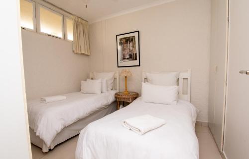 2 Betten in einem Zimmer mit weißer Bettwäsche in der Unterkunft 516 Breakers Resort Umhlanga Rocks in Durban