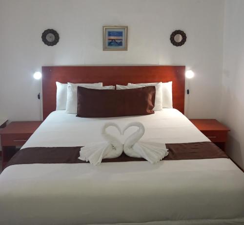 uma cama com dois arcos brancos em Rest Shade Bed and Breakfast em Palapye
