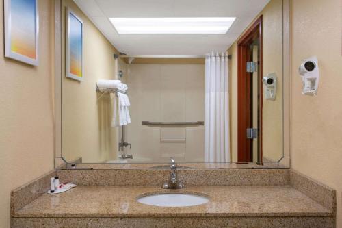 a bathroom with a sink and a large mirror at Days Inn by Wyndham Hillsborough in Hillsborough