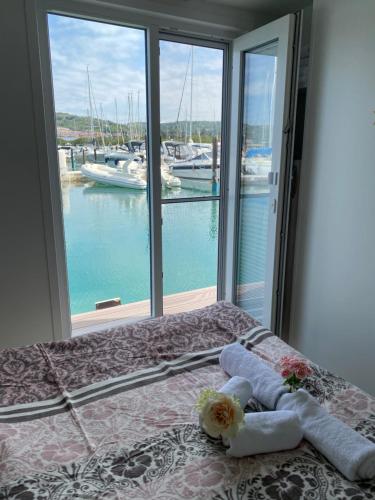 1 dormitorio con 1 cama y vistas al puerto deportivo en Floating House Blue Moon en Portorož