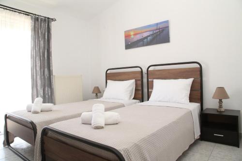 2 camas individuales en una habitación con ventana en Lampias apartments, en Keramotí