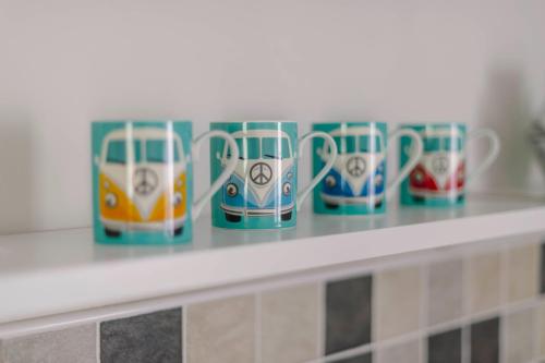 a row of coffee cups sitting on a shelf at Corffe House and Holiday Cottages in Barnstaple