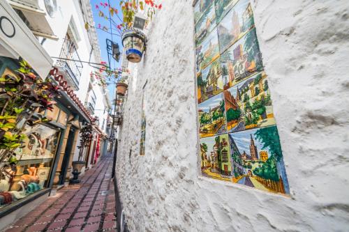an alley with paintings on the side of a building at Óbal Hotel Marbella in Marbella