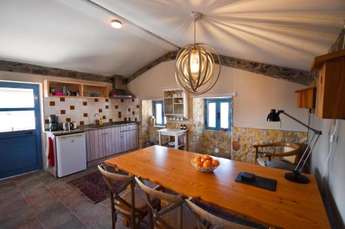a kitchen and dining room with a wooden table at Quinta da Borboleta in Vila Nova de Poiares