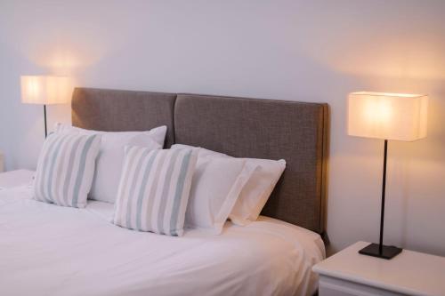 a bedroom with a bed with white pillows and two lamps at Corffe House and Holiday Cottages in Barnstaple