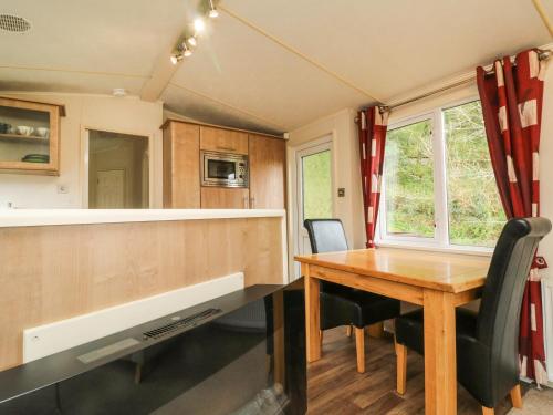 a kitchen and dining room with a wooden table at Exe Valley Lodge in Tiverton