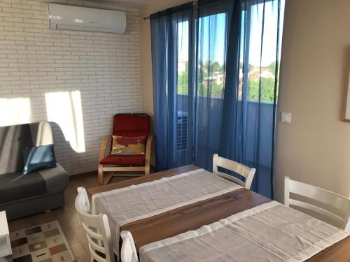 um quarto com 2 camas e uma janela com uma cadeira em апартамент Граф Игнатиев 2 em Yambol