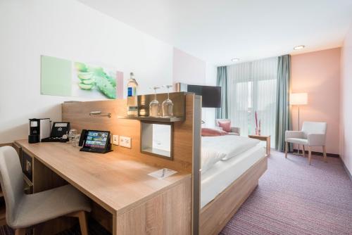 a hotel room with a bed and a desk at Best Western Plus Kurhotel an der Obermaintherme in Bad Staffelstein
