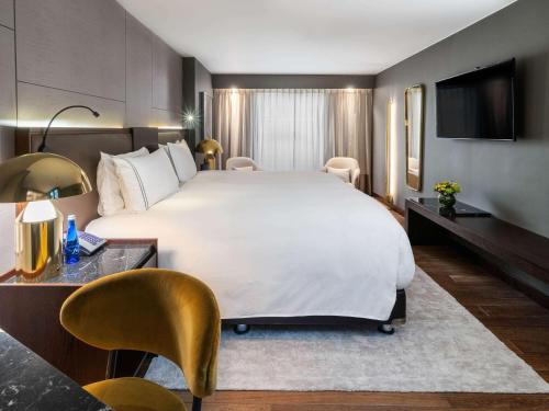 a hotel room with a large bed and a television at Sofitel Bogota Victoria Regia in Bogotá