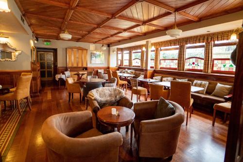 a restaurant with couches and tables and chairs at Littlebury Hotel in Bicester