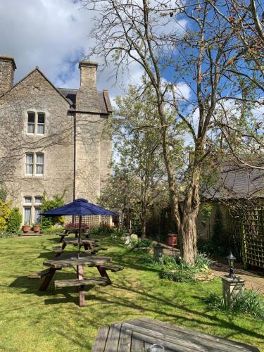 a picnic table and umbrella in front of a building at Littlebury Hotel in Bicester