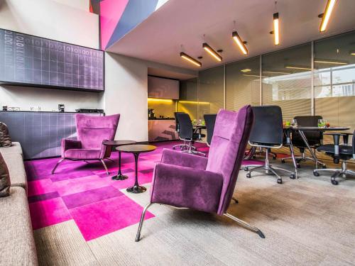 an office with purple chairs and tables in a room at Pullman Sao Paulo Vila Olimpia in Sao Paulo