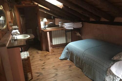 1 dormitorio con 1 cama y lavamanos en una habitación en La Casa de Brieva, en Brieva