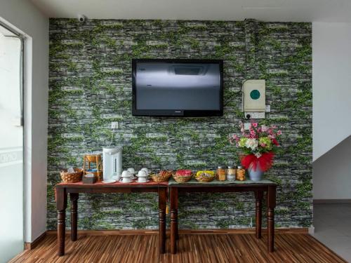 Habitación con mesa y TV en una pared de ladrillo. en Okid Hotel, en Johor Bahru