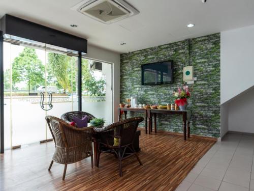 a living room with a table and chairs at Okid Hotel in Johor Bahru