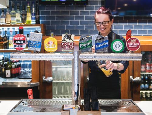 a woman standing behind a counter in a bar at Nightcap at Hendon Hotel in Adelaide