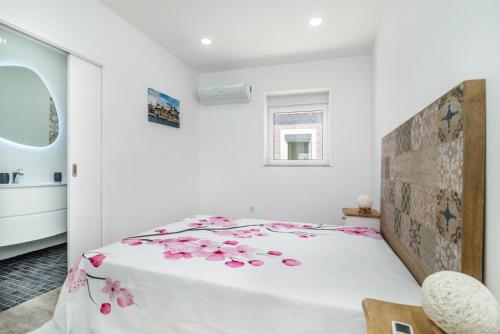 a bedroom with a bed with pink flowers on it at Maredimo Village Porto Casa 5 in Porto