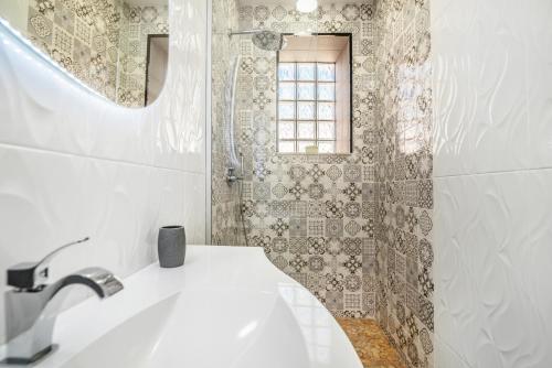 a bathroom with a sink and a shower with a window at Maredimo Village Porto Casa 5 in Porto