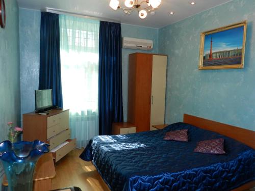 a bedroom with a blue bed and a window at Guest House na Slobodskoy in Saint Petersburg