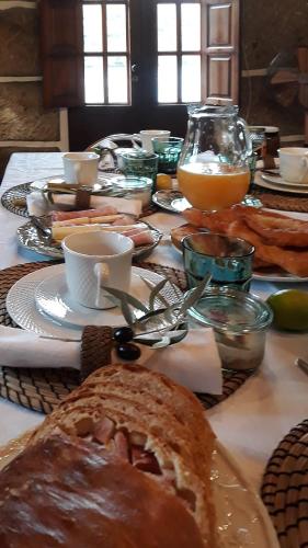 een tafel met een tafel met brood en drankjes bij Casa dos Vinhais Douro Valley in Coleja
