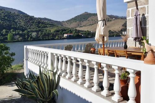 a balcony with a view of the water and mountains at Casa dos Vinhais Douro Valley in Coleja