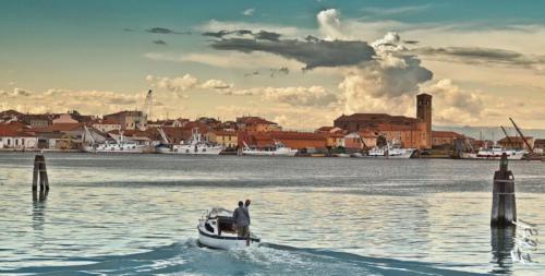 a man on a small boat in the water at Hotel Clodia in Chioggia