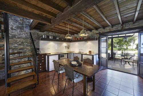 a kitchen with a wooden table and a stone wall at Casa La Palomba in El Pito