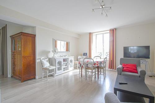 uma sala de estar com um sofá, uma mesa e cadeiras em IKE'S Deluxe APARTMENT in Bayeux em Bayeux