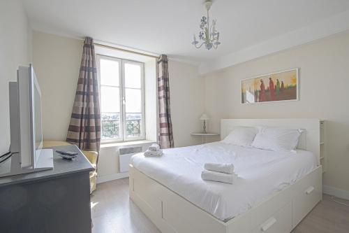 um quarto com uma cama, uma televisão e uma janela em IKE'S Deluxe APARTMENT in Bayeux em Bayeux