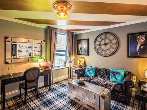 a living room with a couch and a clock on the wall at Mercure Nottingham City Centre Hotel in Nottingham