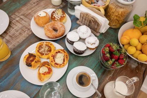 a table with plates of donuts and cups of coffee at Ai Tre Mercati in Palermo