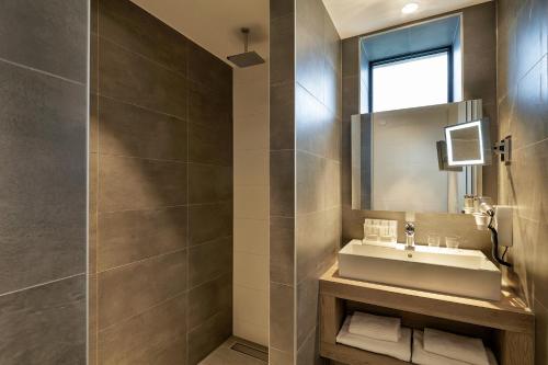 a bathroom with a sink and a mirror at Van der Valk Hotel Breda in Breda