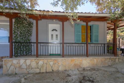 a house with green shutters and a balcony at Country House DAFNI with his pets in Vasilikos