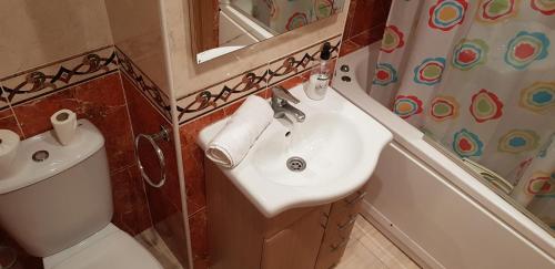 a bathroom with a sink and a toilet and a mirror at Zona Marina Dor - Apartamentos Costa Caribe II in Oropesa del Mar