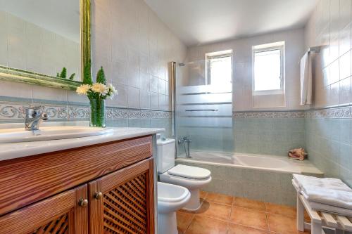 a bathroom with a toilet and a sink and a tub at Country house with amazing pool in a beautiful rural setting in Campanet