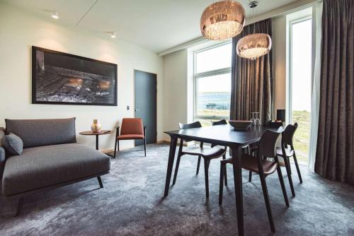 a living room with a table and chairs and a couch at Hotel Brandan in T&oacute;rshavn