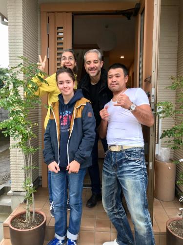 a group of people standing in front of a house at Guest House Branchee in Kushimoto