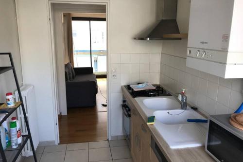 une petite cuisine avec un évier et une cuisinière dans l'établissement Logement 6P BALCON/ MODERNE HYPER CENTRE, à Caen