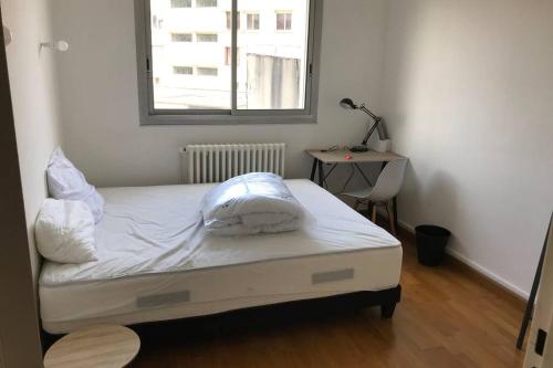 un lit avec des draps blancs et des oreillers dans une chambre dans l'établissement Logement 6P BALCON/ MODERNE HYPER CENTRE, à Caen