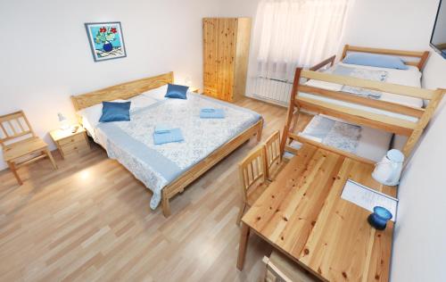 Habitación pequeña con 2 camas y mesa. en Guesthouse Sanabor en Postojna
