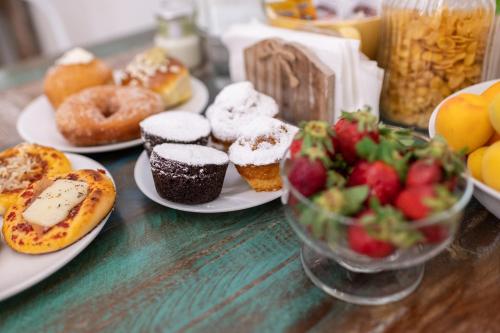 a table with plates of pastries and a bowl of fruit at Ai Tre Mercati in Palermo