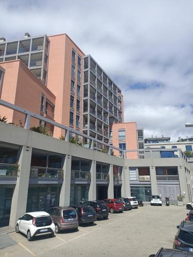 a parking lot with cars parked in front of a building at Appartamenti Lungomare Savona in Savona