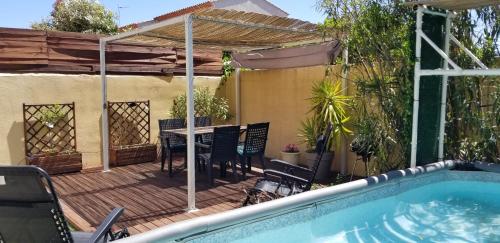 une terrasse avec une table et une piscine dans l'établissement Maison F2, neuve au calme avec jardinet, à La Crau